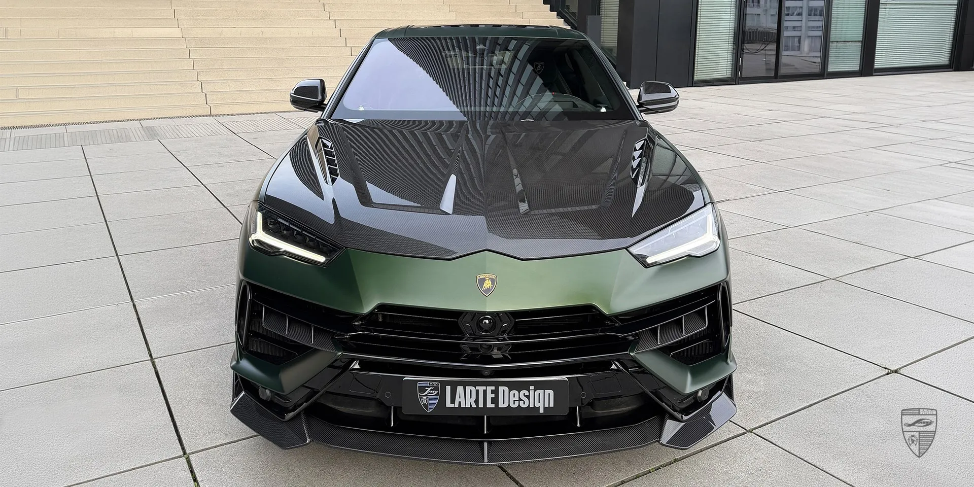 Вид спереди матово‑зелёного Lamborghini Urus S SUV с эксклюзивным дизайном решётки радиатора